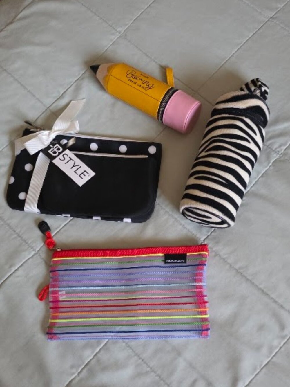 Five assorted cosmetic cases including Benefit, Travelon